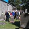 Members of Currie History Society examine a headstone in Currie Kirkyard (June 2011)